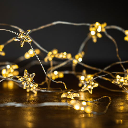 Star-shaped string lights on a reflective surface with a dark background