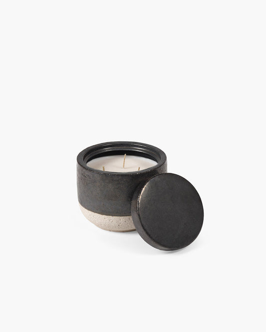 Ceramic candle with black lid on a white background