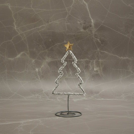 Decorative Christmas tree with a star on top, placed on a marble surface