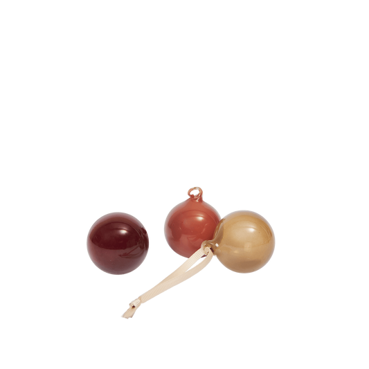 Three wooden beads in red, brown, and beige on a white background