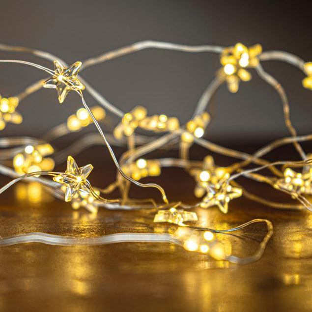 Star-shaped string lights on a reflective surface with a dark background