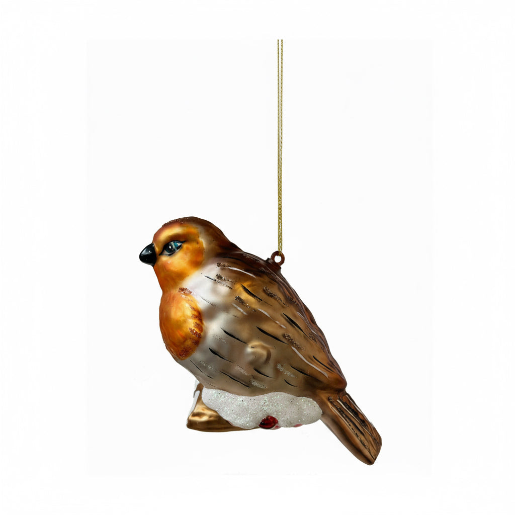 Glass ornament of a bird with brown, white, and black colors on a white background
