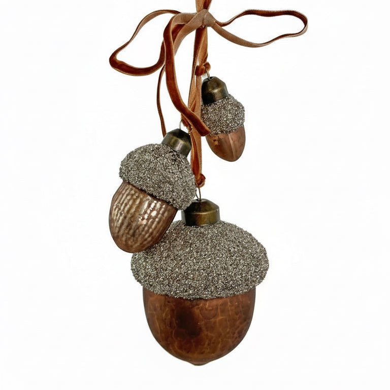 Decorative acorn ornaments with glittery caps on a white background