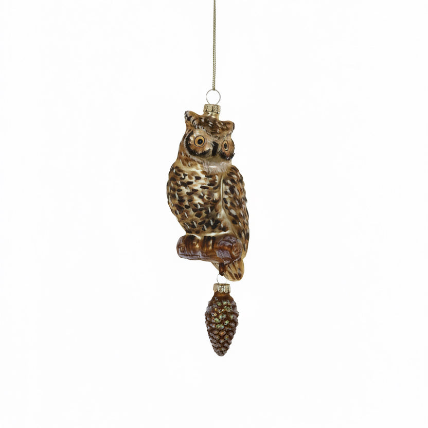Decorative owl ornament with pine cone on a white background