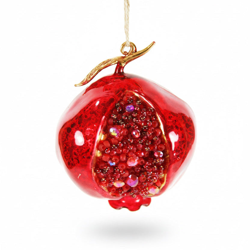 Red glittery apple-shaped ornament with a gold stem on a white background