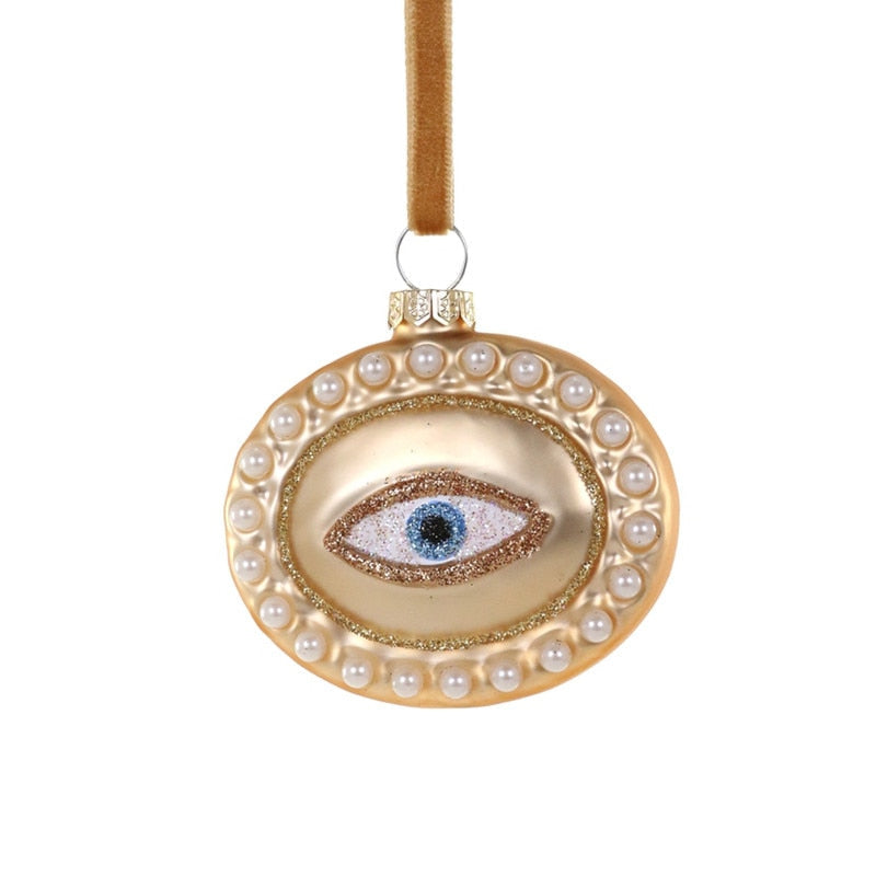 Decorative ornament with an eye design and pearl embellishments on a white background