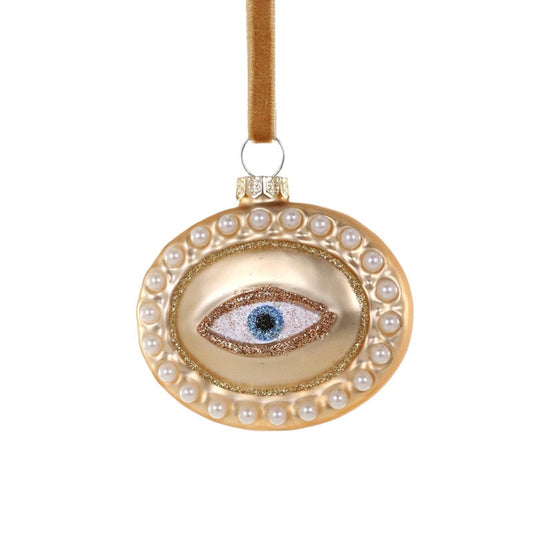 Decorative ornament with an eye design and pearl embellishments on a white background