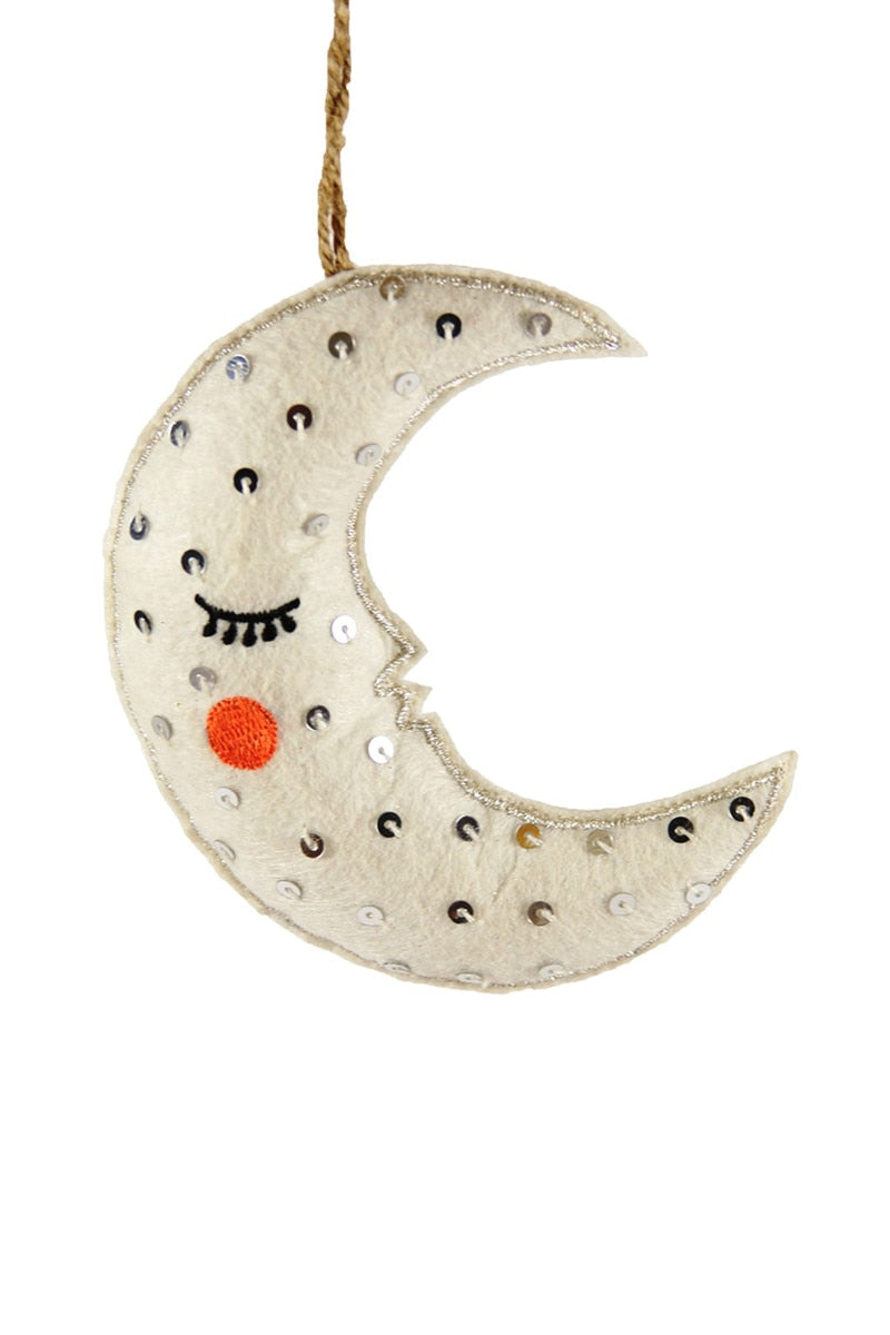 Decorative moon-shaped hanging ornament with eyes and a red dot on a white background
