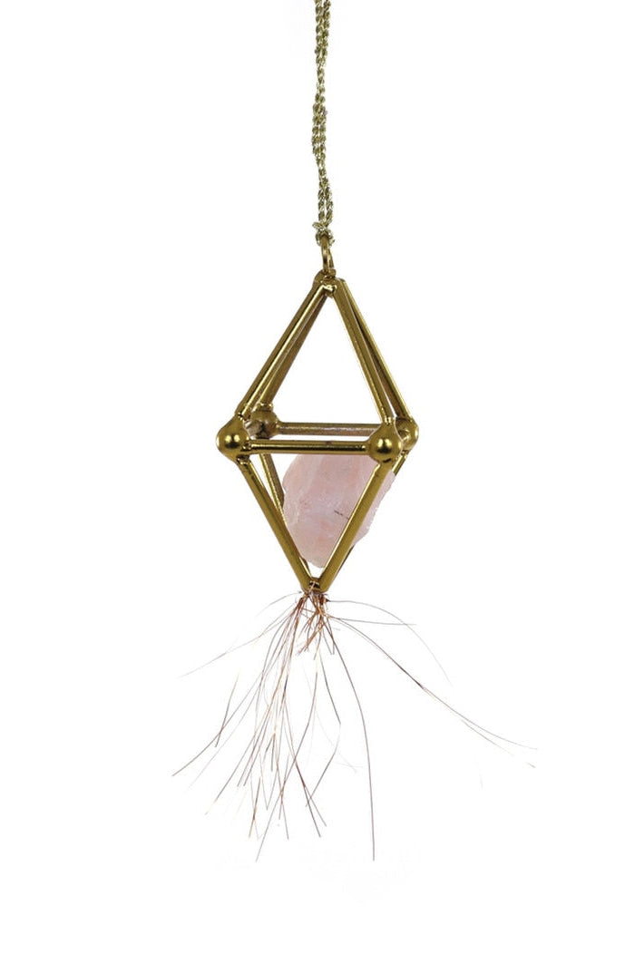 Decorative hanging item with geometric gold frame and pink center on a white background