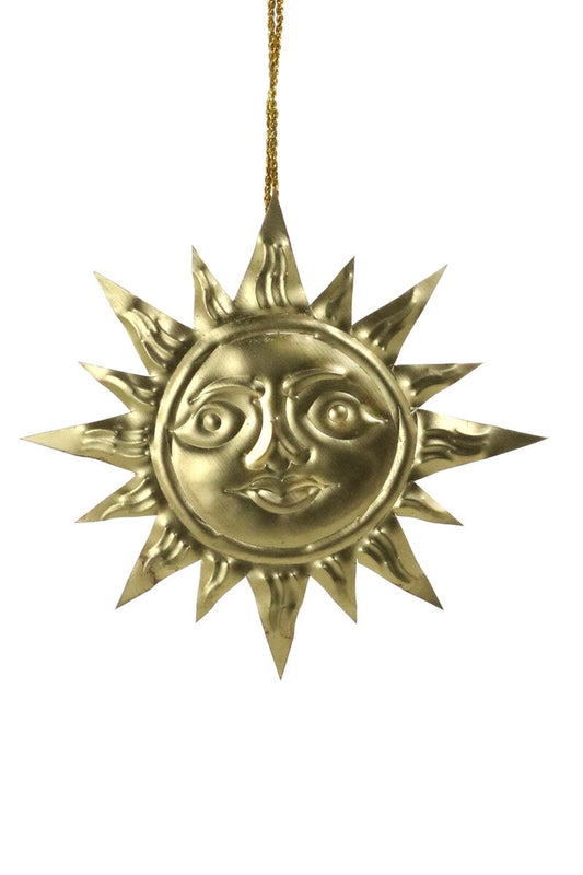 Gold sun-shaped ornament with face on a white background