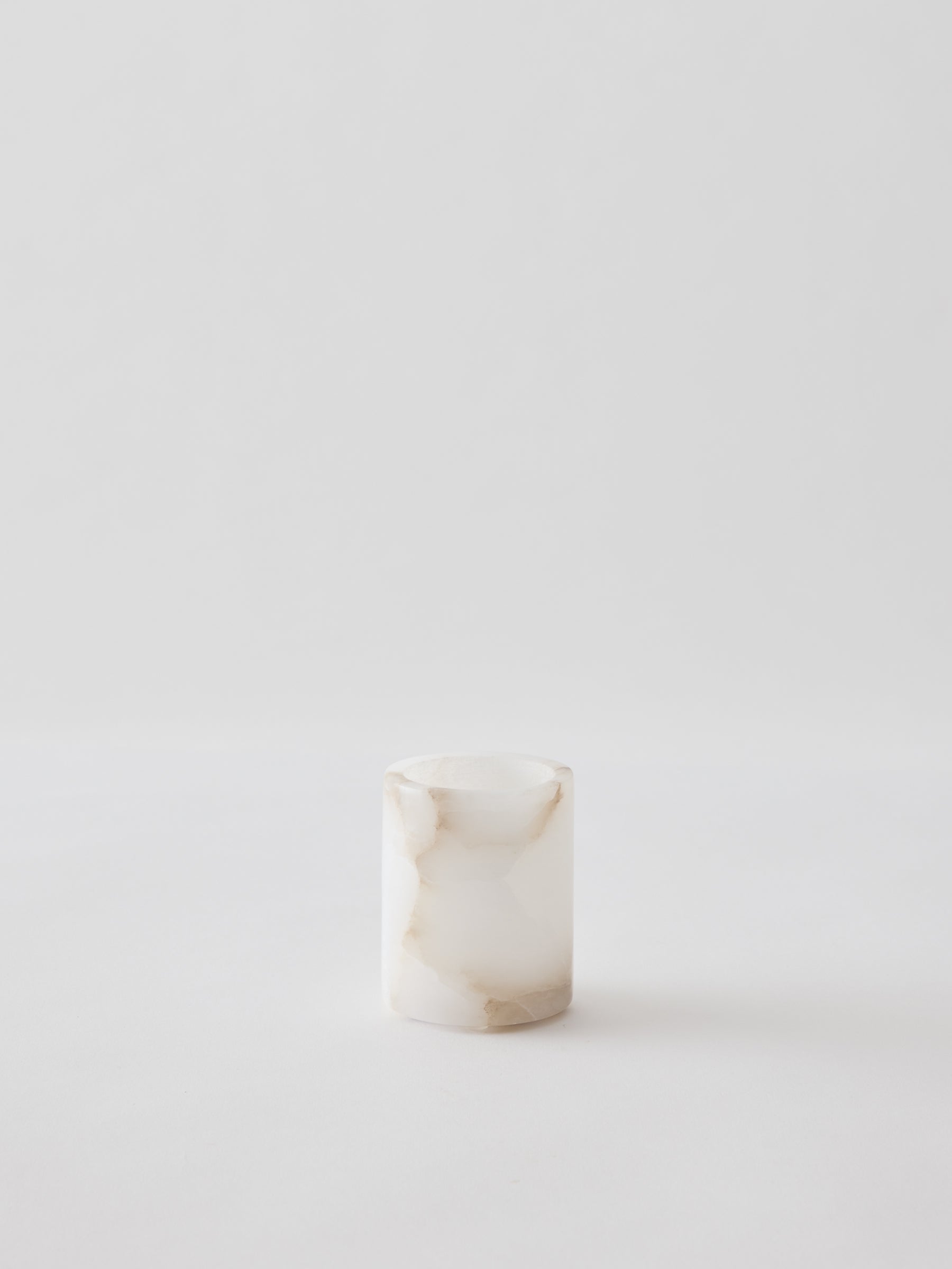 Small cylindrical marble container on a white background