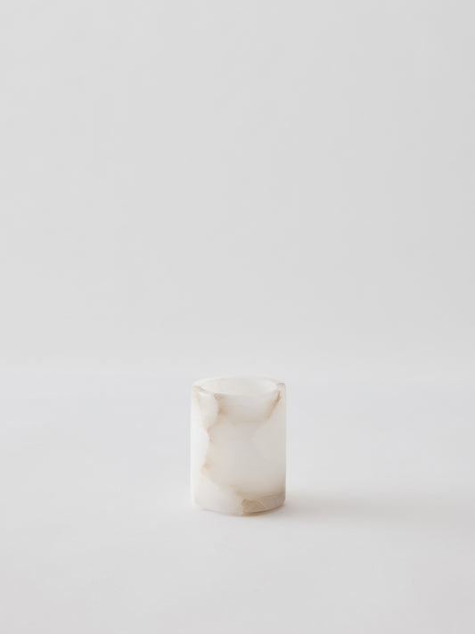 Small cylindrical marble container on a white background