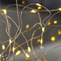 String of small lights on thin wires against a dark background