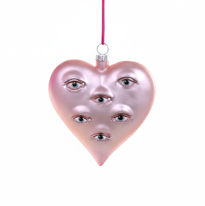 Pink heart-shaped ornament with face design on a white background