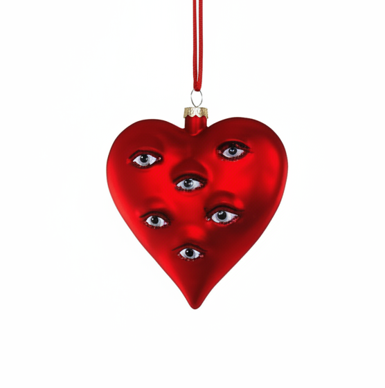 Red heart-shaped ornament with faces and eyes on a white background