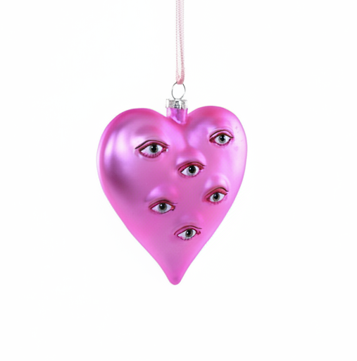 Pink heart-shaped ornament with multiple eyes on a white background