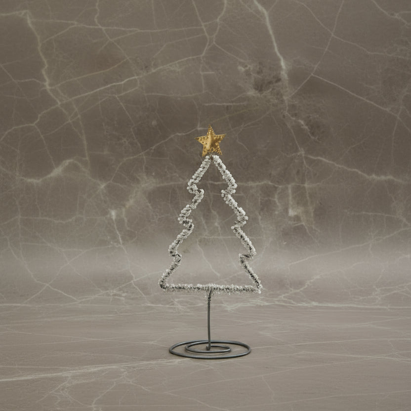 Decorative Christmas tree with a star on top, placed on a marble surface